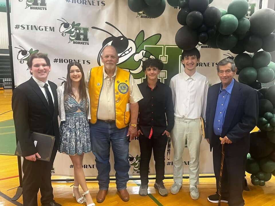 Four graduating Hemphill scholarship recipients with two Hemphill Lions Club members at a school awards night